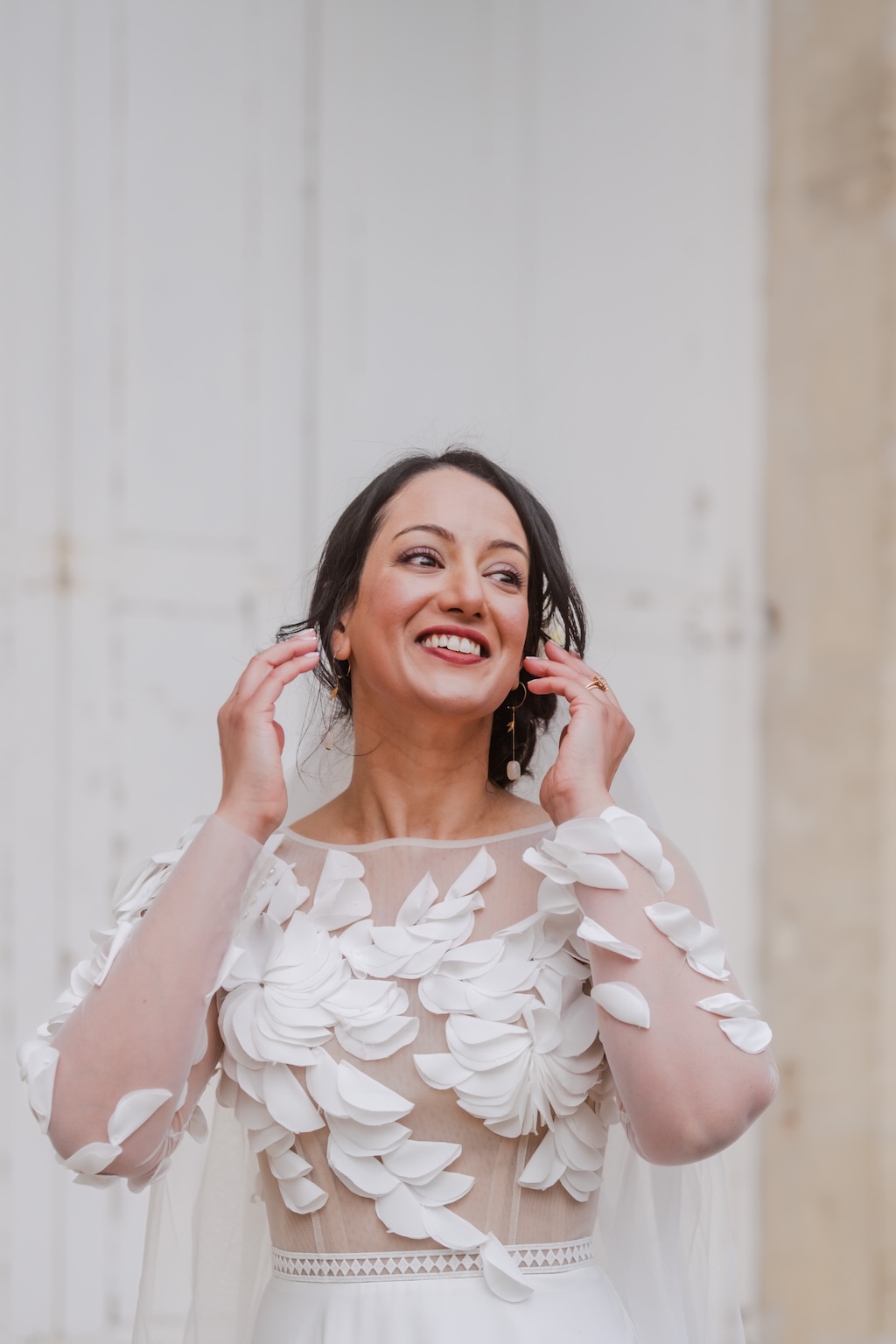 Portrait d'une femme souriante devant une porte en bois