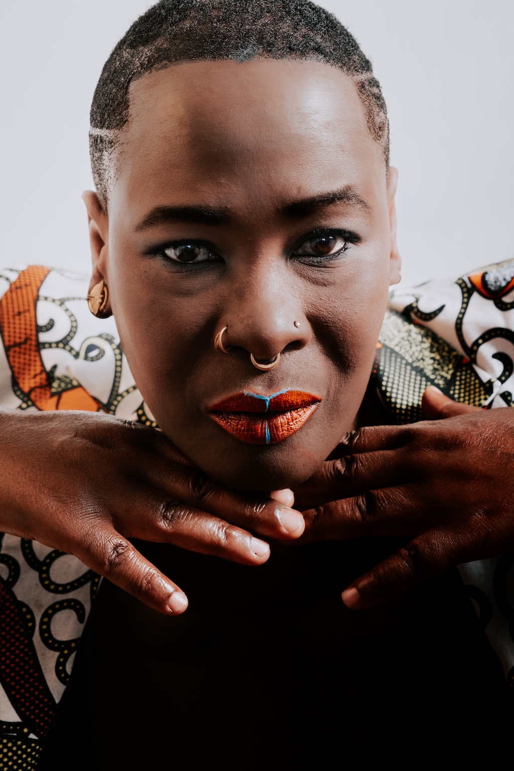 Portrait de face d'une femme noire avec un maquillage coloré