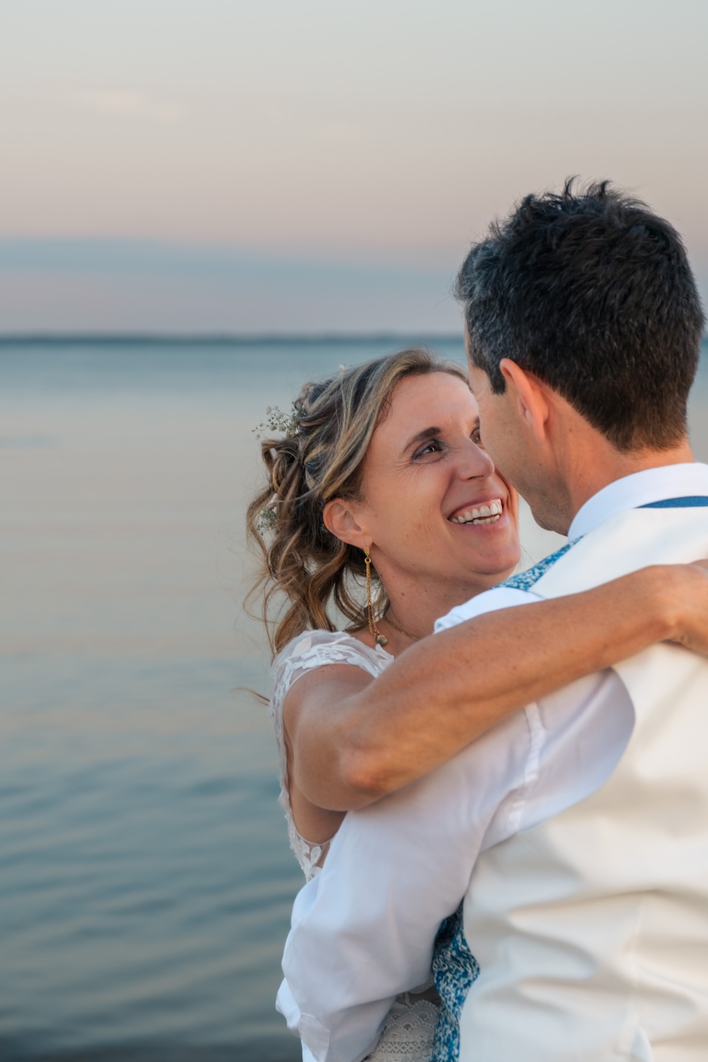 Un homme et une femme s'embrassant sur la plage le jour de leur mariage