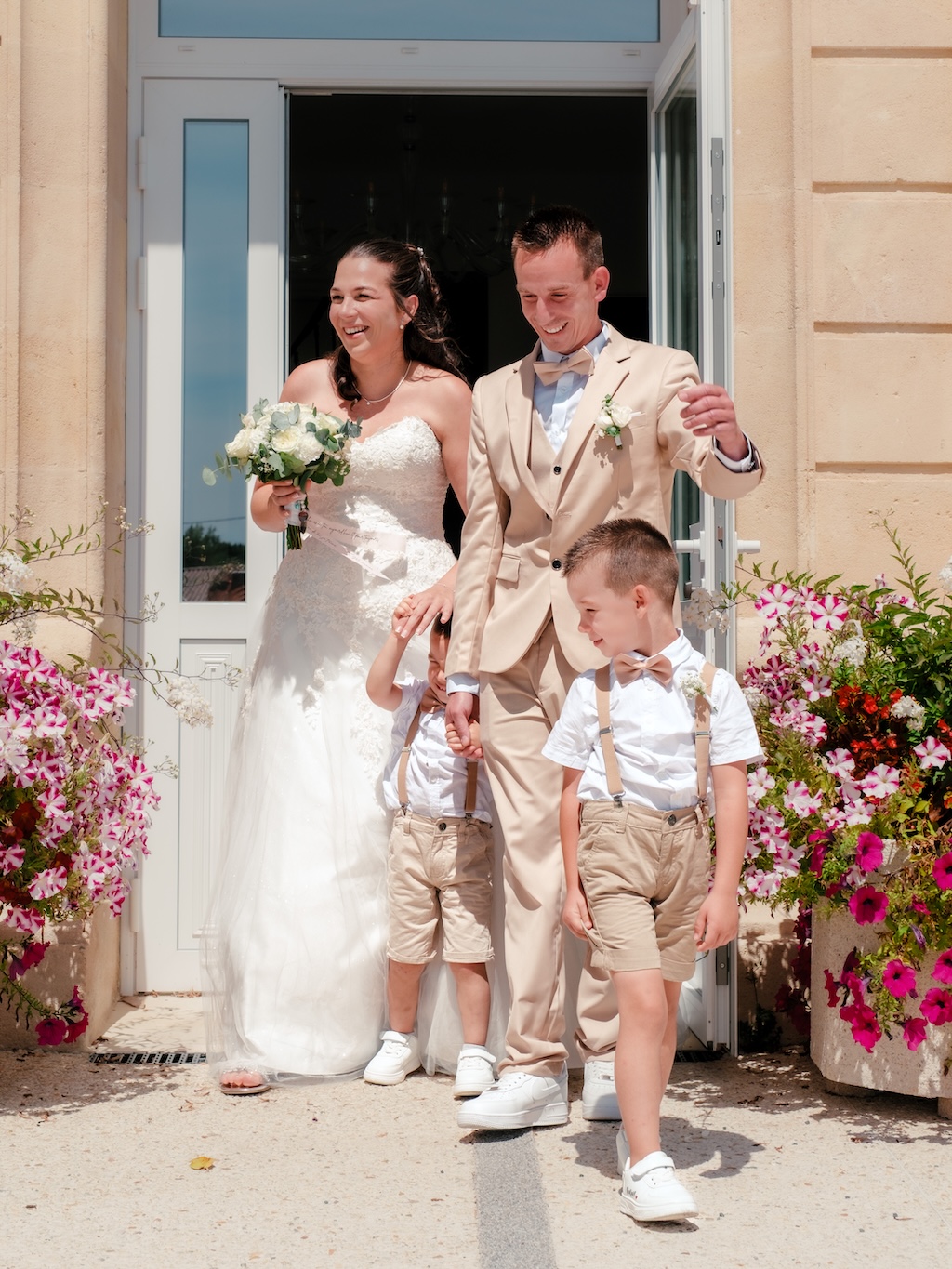 Une couple marié sortant de mairie de Paris après leur cérémonie de mariage, accompagnés de leurs enfants