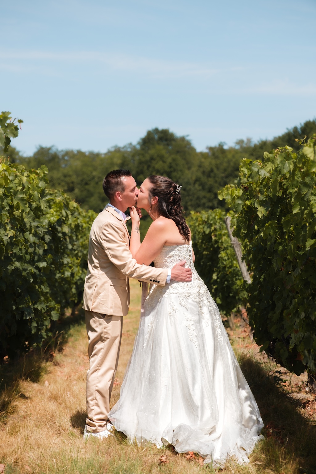 Coupe s'embrassant dans un champ de vigne pour leur mariage en région parisienne