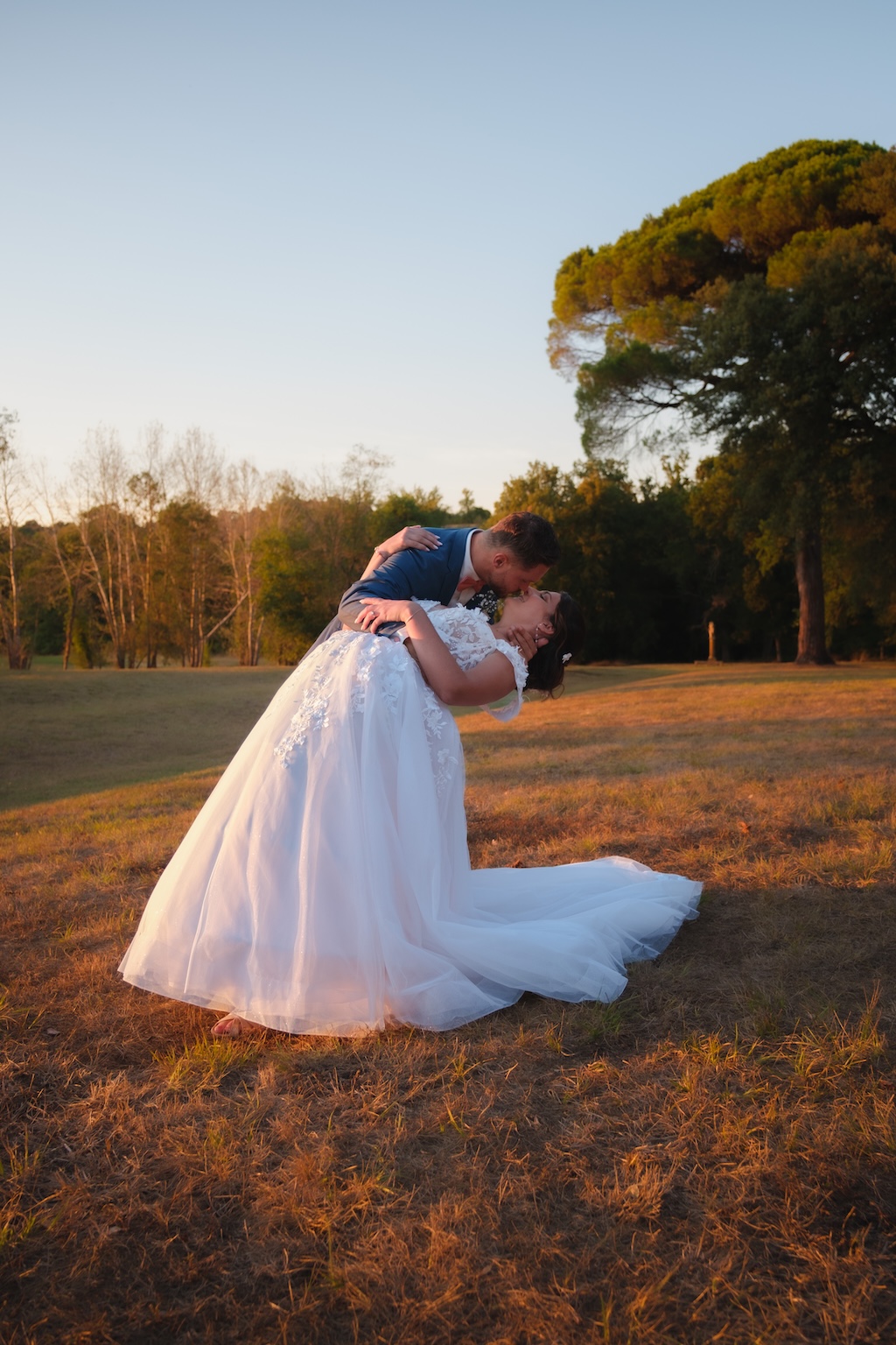 Photo de couple dans un jardin au coucher du soleil avec une lumière douce et chaude
