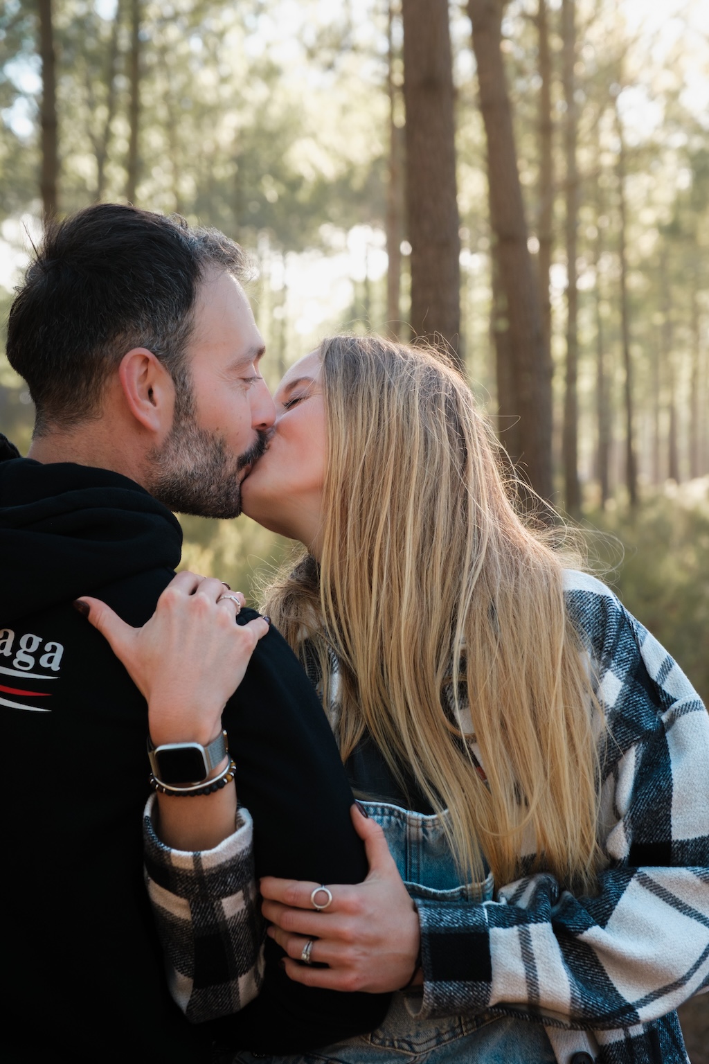 Un couple se baladant en forêt, lumière douce et chaude
