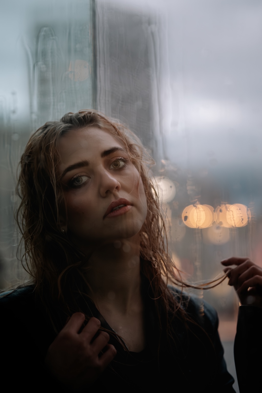 Le portait d'une femme sous la pluie en fin de journée avec une lumière douce de début de soirée