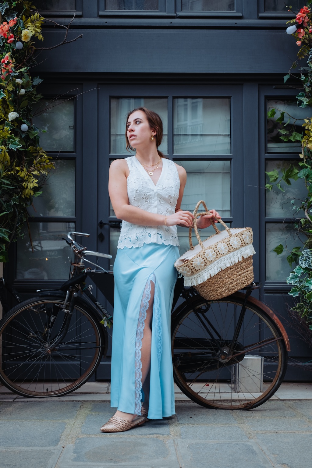 Une femme devant son vélo portant une corbeille de fruit, lumière douce et style éditorial