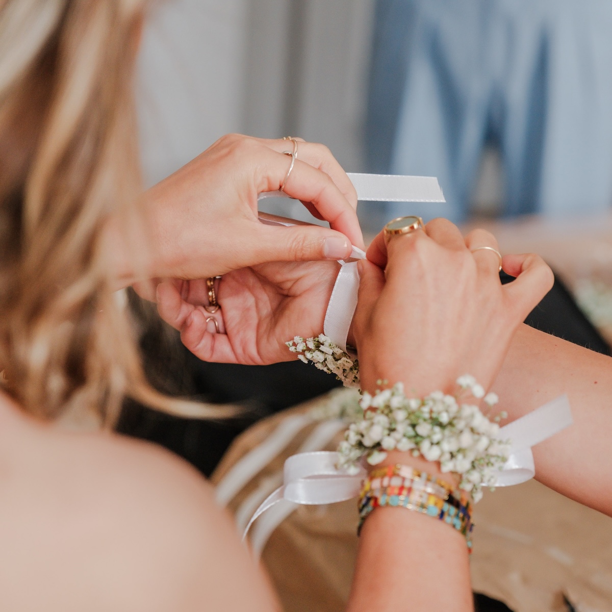Plan serré sur les mains de la mariée et de se demoiselle d'honneur attachant un bracelet