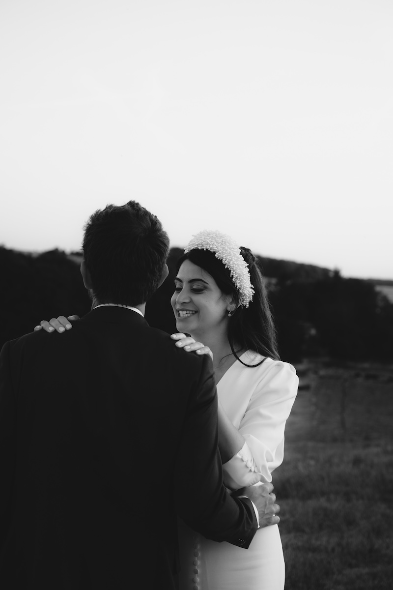 Mariée souriante face à son mari dans le jardin d'un domaine de mariage