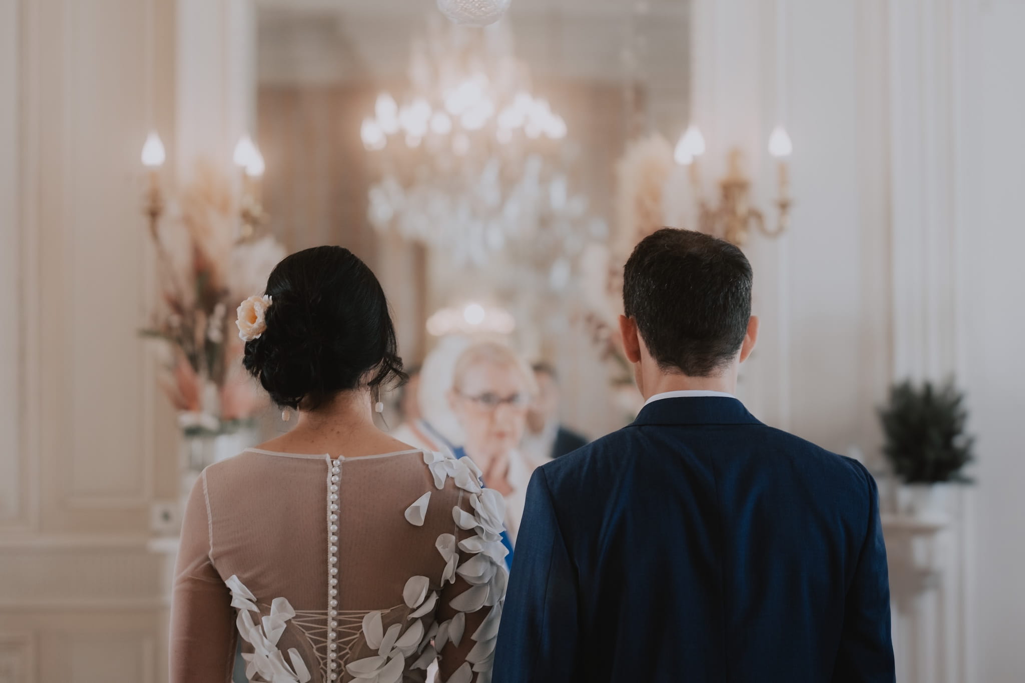 Mariés de dos se tenant la main devant dans une mairie de Paris